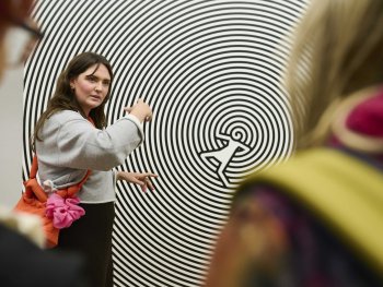 Eine Kunstvermittlerin vor einem Bild der Ausstellung Christoph Niemann bei einer Führung