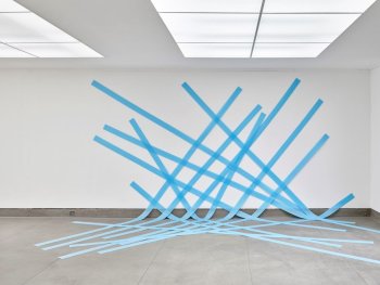 Foto: © 2026 VG Bild-Kunst, Bonn für die Werke von Kirstin Arndt; Courtesy: Galerie Mathias Güntner, Hamburg/Berlin und GREEN ON RED GALLERY, Dublin; Foto: Achim Kukulies
Blaue Dämmkunststoffstreifen in 14 Bahnen über eine Wand und den Boden des Raums geklebt, beziehen sich auf die Maße des Raums