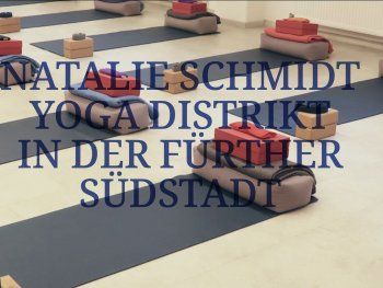 Mehrere Yogamatten mit zusammengefalteten Decken und kleinen Holzkästen