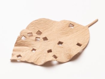 Geschnitztes Blatt aus Holz mit mehreren quadratischen Löchern