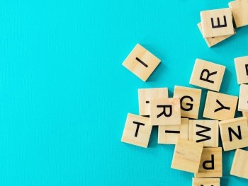 Buchstabenplättchen aus Holz auf türkisfarbenem Grund
