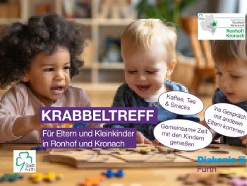 Zwei Kleinkinder sitzen an einem Tisch mit Spielzeug