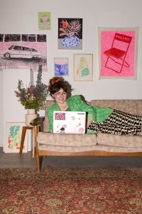 Pia Salzer auf ihrem Sofa vor ihren Werken