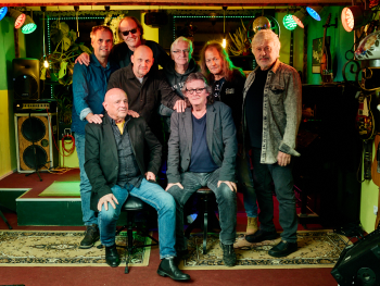 Das Foto zeigt die achtköpfige NC Brown Blues Band lächelnd auf einer Bühne posieren.