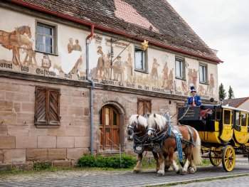 zwei Pferde ziehen die Museums-Postkutsche