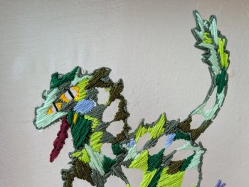 Copyright: Leander Gerhaher Eine gestickte bunte Fantasie-Kreatur mit grünem Körper und geschwungenem Schwanz.