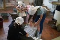 Kinder waschen Wäsche wie im Jahr 1900 - Mit Waschzuber, Waschbrett, Bürste und Kernseife wird die Wäsche sauber geschrubbt