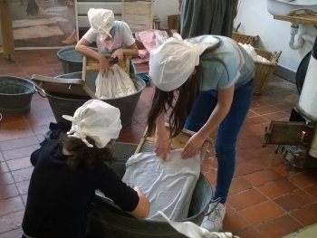 Kinder waschen Wäsche wie im Jahr 1900 - Mit Waschzuber, Waschbrett, Bürste und Kernseife wird die Wäsche sauber geschrubbt