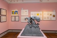 Im Mittelpunkt steht eine Betonskulptur von Walter Moers Kleinem Arschloch. Im Hintergrund hängen gerahmte Zeichnungen an der Wand.