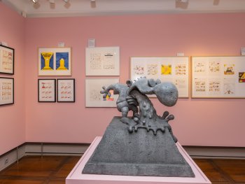 Im Mittelpunkt steht eine Betonskulptur von Walter Moers Kleinem Arschloch. Im Hintergrund hängen gerahmte Zeichnungen an der Wand.