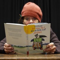 Eine Frau mit roter Mütze liest ein Buch