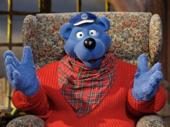 Auf einem Sessel sitzt die Filmpuppe Käpt’n Blaubär.