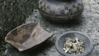 bemalte Tongefäße, eine Schale enthält verschieden große Gesteinsbrocken