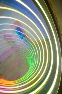 Spiralförmig angeordnete Lichter in Regenbogenfarben erzeugen einen hypnotischen Tunnel-Effekt.