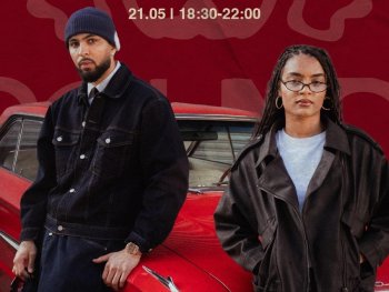 Zwei Personen sitzen Auf der Motorhaube eines roten Autos