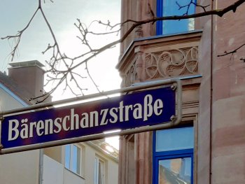 Straßenschild "Bärenschanzstraße" vor Hausfassade mit schöner Verzierung