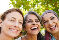 drei Frauen, die in die Kamera lächeln