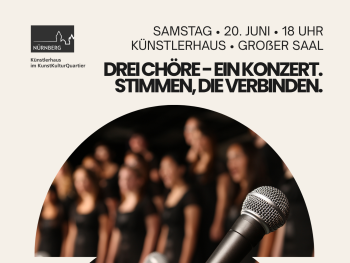 Drei Mikrofone im Fokus vor unscharfem Hintergrund mit Chormitgliedern in schwarzer Kleidung