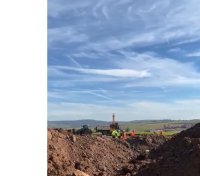 Baustellenbereich mit aufgeschütteter Erde unter blauen Himmel