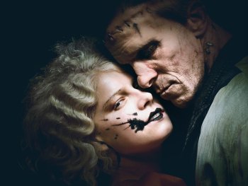 Copyright: Warner Bros. Pictures Germany Zwei Personen mit theatralisch-dunklem Make-up liegen Wange an Wange in einer düsteren, dramatischen Szene.