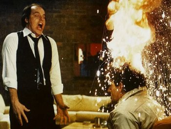 Copyright: Filmverleih Schreiende Person in Hemd und Weste steht neben einer anderen Person, deren Kopf in Flammen und Funken gehüllt ist.