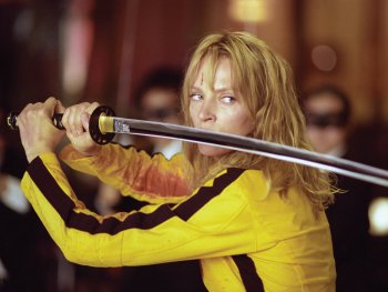 Copyright: 2003 MIRAMAX. ALL RIGHTS RESERVED Eine Person in gelbem Kampfanzug hält entschlossen ein Katana-Schwert vor sich, das Gesicht mit einer Schnittwunde gezeichnet.
