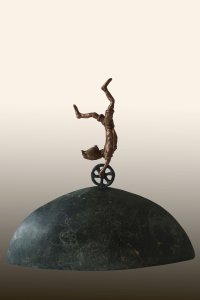 Bronzeskulptur einer akrobatisch kopfstehenden Person auf einem Einrad, das auf einem halbkugelförmigen grünen Serpentinsockel balanciert.