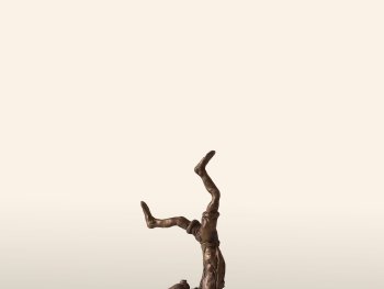 Foto: Reiner Fritsche, VNP
Bronzeskulptur einer akrobatisch kopfstehenden Person auf einem Einrad, das auf einem halbkugelförmigen grünen Serpentinsockel balanciert.