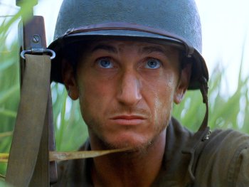 Copyright: 20th Century Fox Ein Soldat mit Stahlhelm und Gewehr kauert schwitzend im hohen Gras und blickt angespannt in die Ferne.