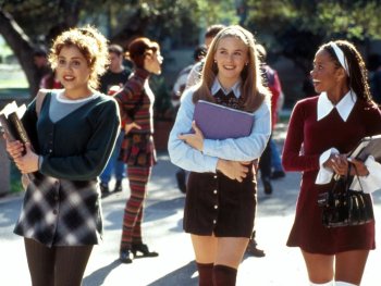 Copyright: Paramount Pictures Drei junge Frauen in modischer 90er-Jahre-Kleidung mit Büchern und Mappen gehen lächelnd über einen Schulcampus.