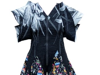 Schwarzer Jumpsuit mit weit ausgestellten Beinen, verziert mit bunten Skelettmustern, die in Schultüten enden, und flügelartigen schwarz-weißen Ärmeln.