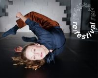 Eine tanzende Person liegt in einer verdrehten Körperhaltung am Boden, umgeben vom kreisförmig angeordneten Schriftzug „re:festival re:festival“.