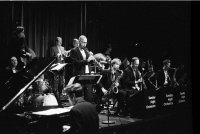 In schwarz-weiß ist eine große Band zu sehen mit vielen Instrumenten.