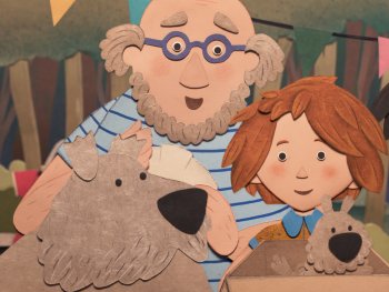 Copyright: Luftkind Filmverleih
Papierfiguren aus Stop-Motion-Animation zeigen einen älteren Mann, ein Kind und eine Person mit Basecap und „RURAL“-Shirt neben einem zotteligen Hund in einer Kiste.