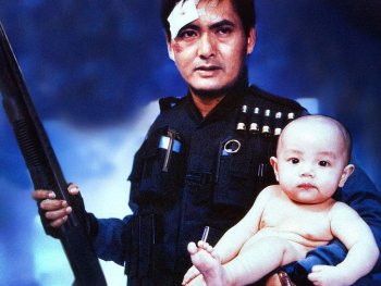 Copyright: Rapid Eye Movies Verletzter Mann hält eine Schrotflinte in einer Hand und ein Baby im anderen Arm.