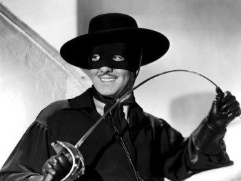 Copyright: Images courtesy of Park Circus; Disney
Historische Schwarz-Weiß-Aufnahme einer maskierten Person im Zorro-Kostüm mit breitkrempigem Hut, die lächelnd ein Florett und eine Peitsche in den Händen hält.