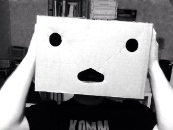 Copyright: Kommkino e. V.
Person mit Kartonschachtel als Maske über dem Kopf und T-Shirt mit der Aufschrift „Komm Kind“ in schwarz-weißer Aufnahme.