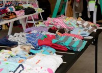 Bunte Kinderkleidung auf einem Tisch ordentlich ausgebreitet.