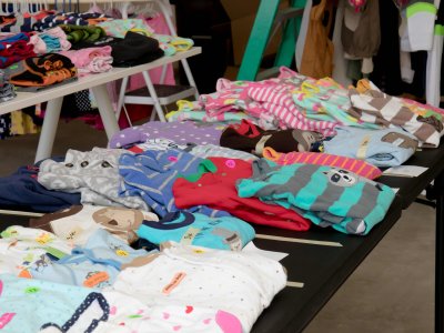 Bunte Kinderkleidung auf einem Tisch ordentlich ausgebreitet.