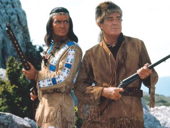 Copyright: Filmverleih Zwei Männer in traditioneller Lederkleidung stehen mit Gewehren in einer felsigen Landschaft.