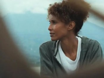 Copyright: Filmverleih
Person mit lockigem Haar blickt zur Seite, im Hintergrund eine hügelige Landschaft im Dunst.