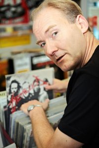 Frank Schäfer durchsucht in einem Plattenladen ein Regal mit Schallplatten, darunter ein Album von Metallica.