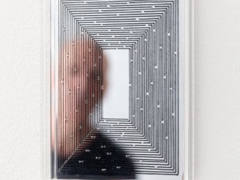 Copyright: Andreas Oehlert, Ariadne (C), Detail, Ed. 10, 2026, Stickgarn, Acrylglasspiegel, Acrylglas, 20,5 x 15 x 2,5 cm; Gerahmtes Kunstwerk mit konzentrischem Linienmuster auf spiegelnder Oberfläche, in dem sich eine unscharf zu sehendePerson spiegelt.