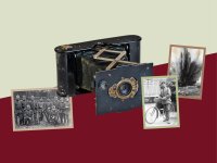 Collage aus einer historischen Balgenkamera und historischen Schwarzweißfotos von Soldaten, einem Radfahrer in Uniform und einer Explosion.