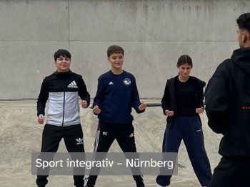 Drei Jugendliche in Sportkleidung trainieren mit geballten Fäusten, während eine Trainerperson vor ihnen steht, Bildtitel „Sport integrativ – Nürnberg“.