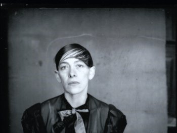 Copyright: Neue Visionen Filmverleih Historische Schwarz-Weiß-Porträtaufnahme von Helene Weigel mit zurückgekämmtem Haar und Seitenscheitel in dunkler Bluse mit Schleife vor neutralem Hintergrund.