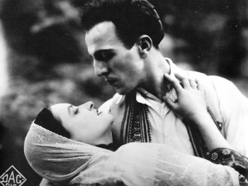 Copyright: Cinemathek Athen Szenenbild aus dem Film ASTERO. Schwarz-weiße Filmszene, in der ein Mann und eine Frau in enger Umarmung einander zärtlich ansehen, sie trägt einen Schleier.