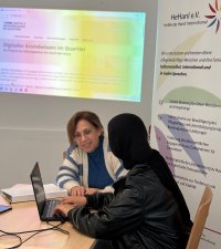 Frau zeigt anderer Frau etwas am Laptop