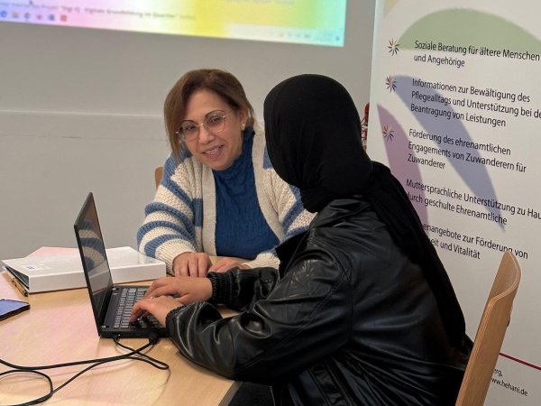 Frau zeigt anderer Frau etwas am Laptop