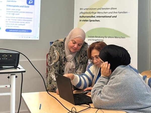 Frau zeigt Frauen etwas an einem Laptop